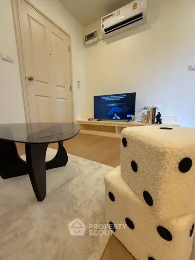 Cozy living room with modern decor, featuring a stylish black table and unique dice-shaped stools.