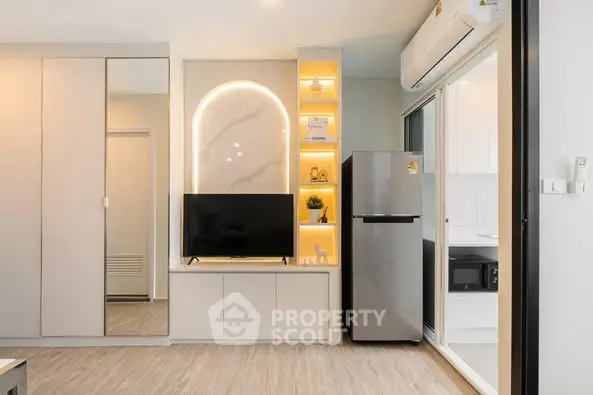 Modern living room with sleek design, featuring TV, fridge, and stylish decor.