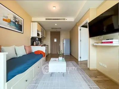 Modern living room with cozy seating, wall-mounted TV, and stylish decor in a contemporary apartment.
