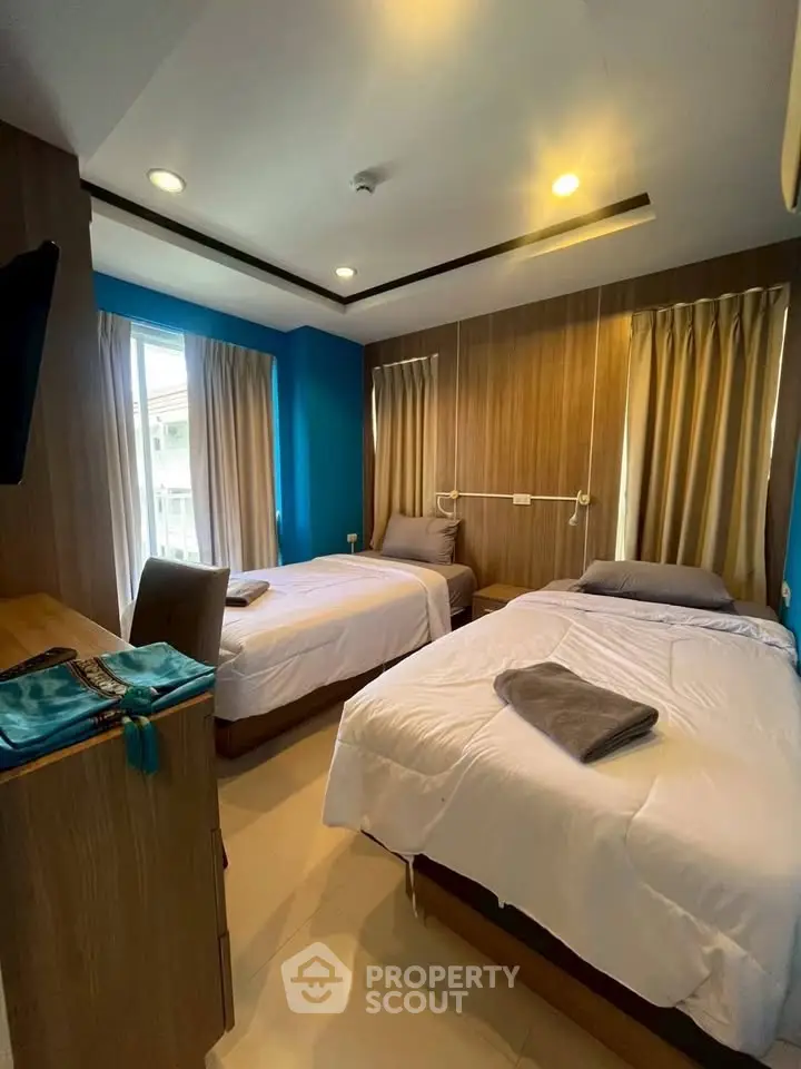 Modern twin bedroom with stylish decor and ample natural light