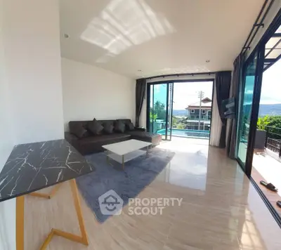 Spacious living room with modern decor and large windows offering scenic views.