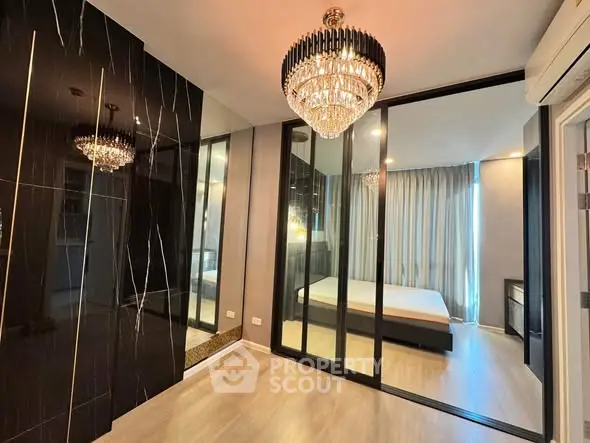 Luxurious bedroom with elegant chandelier and mirrored wardrobe doors