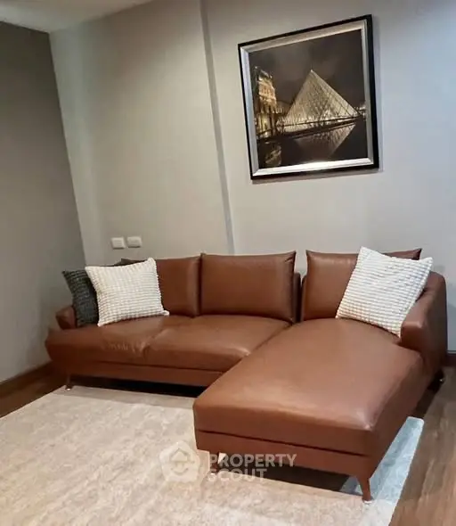 Stylish living room with brown leather sofa and modern art on wall