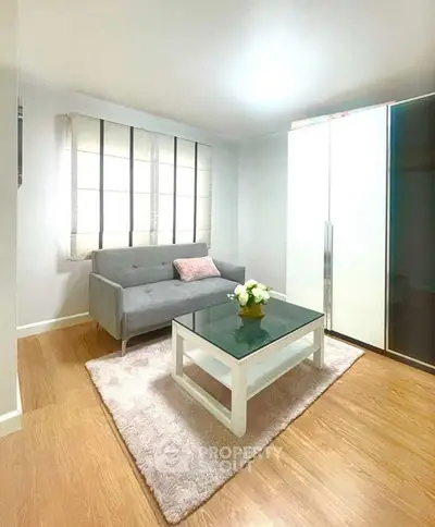 Chic living room with modern sofa, glass coffee table, and elegant decor in a cozy apartment.