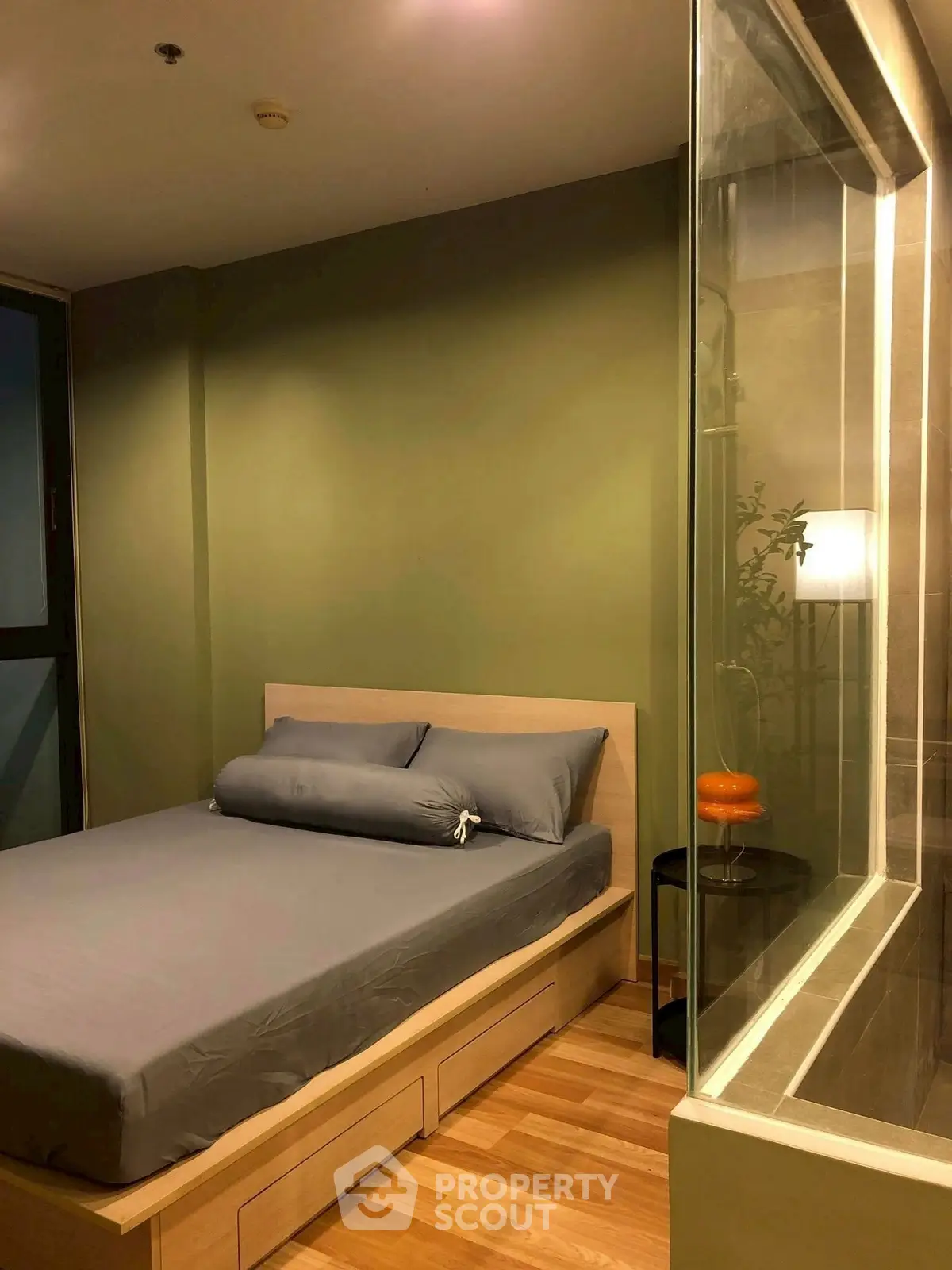 Cozy bedroom with modern design and glass partition for a stylish urban living experience.