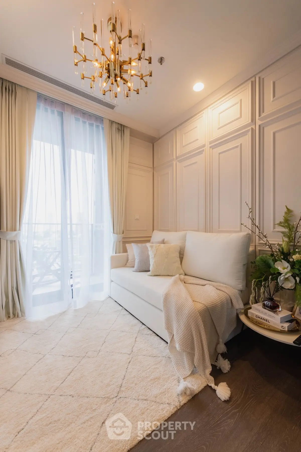 Elegant living room with plush sofa, chandelier, and soft lighting