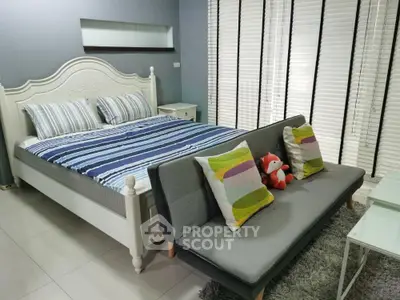 Charming bedroom with stylish decor and cozy seating area, perfect for relaxation and comfort.