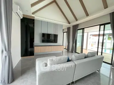 Spacious modern living room with vaulted ceiling and pool view, perfect for luxury living.