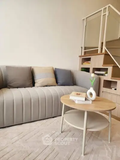 Modern living room with stylish sofa and chic coffee table near staircase