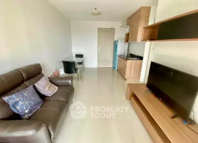 Modern living room with sleek furniture and compact kitchen in open layout apartment.