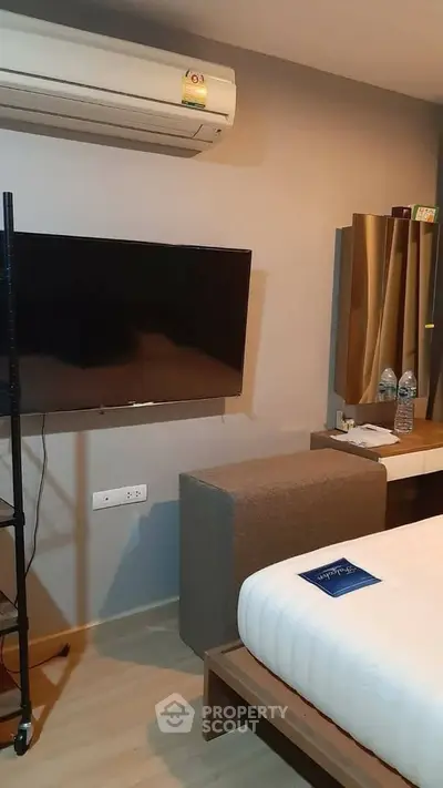Modern bedroom with air conditioning and wall-mounted TV in cozy apartment.
