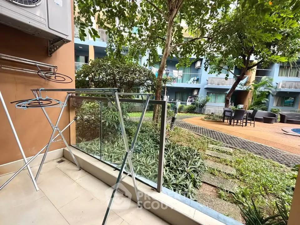 Charming garden view from a cozy balcony in a modern apartment complex.
