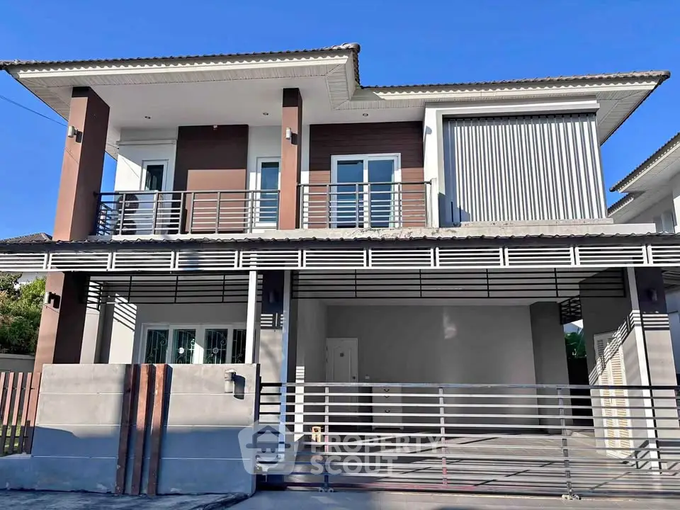 Modern two-story house with sleek design and spacious garage in a suburban neighborhood.