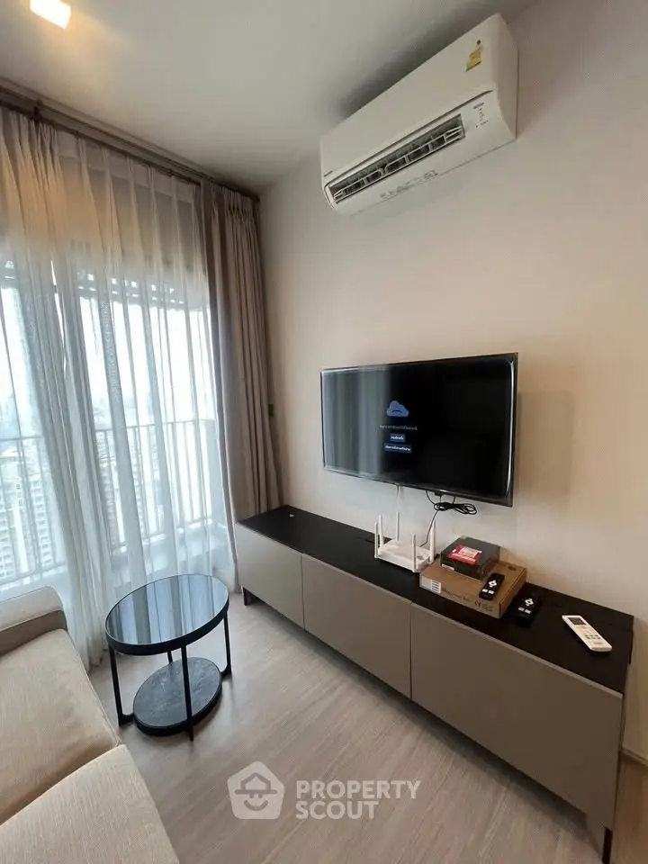 Modern living room with air conditioning and sleek TV setup in a high-rise apartment.