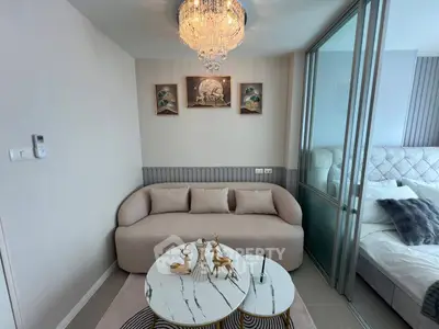 Elegant living room with modern decor and glass partition to bedroom