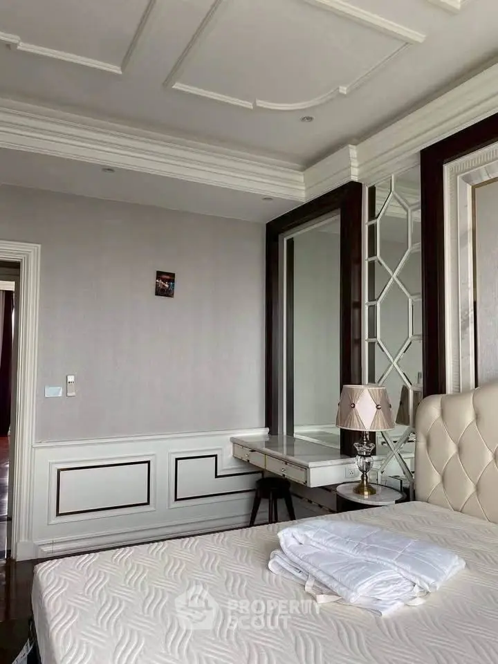 Luxurious bedroom with elegant decor and plush bedding in a modern apartment.