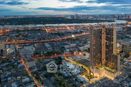 Stunning aerial view of a modern high-rise building with cityscape and river backdrop.