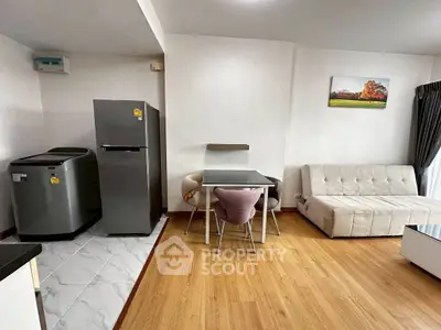 Modern living room with sleek furniture and appliances in a cozy apartment setting.