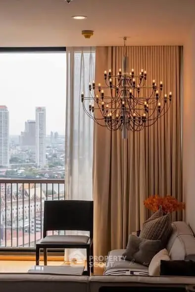 Luxurious living room with chandelier and stunning city view from high-rise apartment.