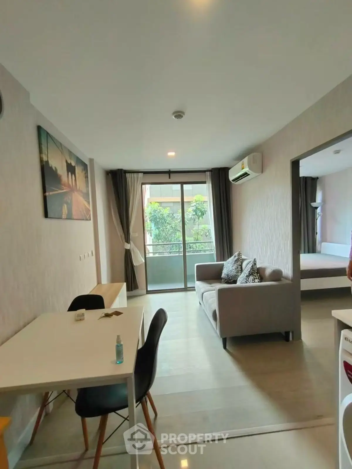 Modern living room with balcony view, stylish decor, and natural light