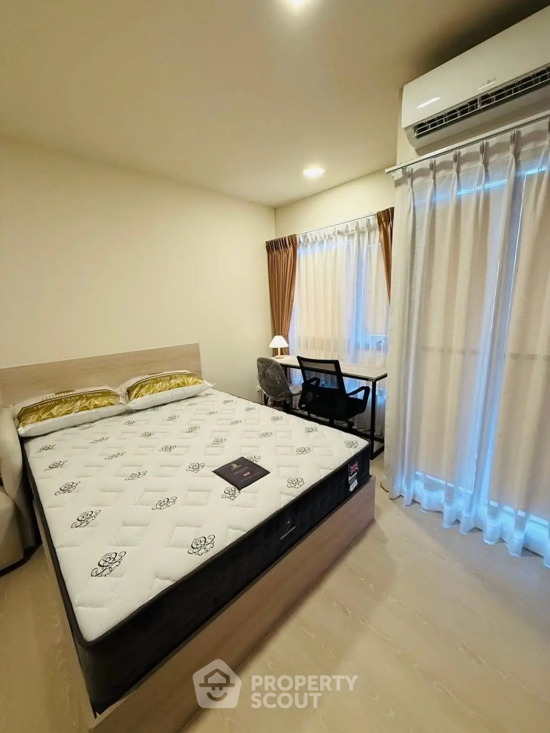 Modern bedroom with large window and desk, featuring a comfortable bed and air conditioning.