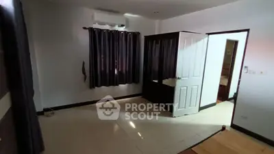 Spacious bedroom with dark curtains and built-in wardrobe