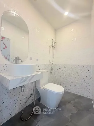 Modern bathroom with sleek design and elegant fixtures, featuring a stylish sink and contemporary toilet.