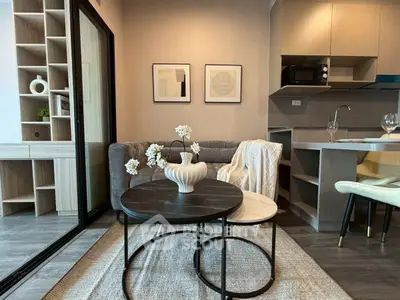 Modern living room with stylish decor and open kitchen layout in a cozy apartment.