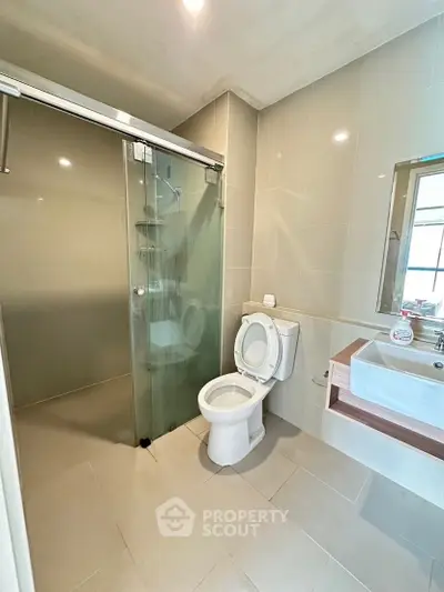 Modern bathroom with glass shower and sleek fixtures in a contemporary home.