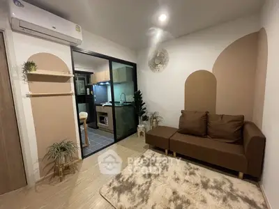 Cozy living room with modern kitchen view, featuring stylish decor and comfortable seating.