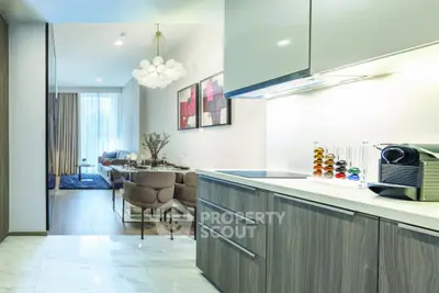 Modern open-layout kitchen and living room with stylish decor and natural light.