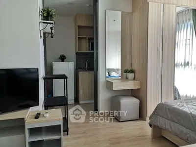 Modern studio apartment with cozy bedroom and compact kitchen area, featuring stylish decor and natural light.