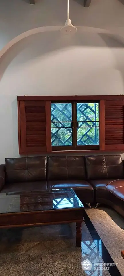 Spacious living room with leather sofa and large window