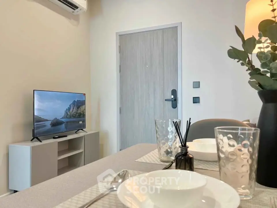 Modern living room with stylish decor and flat-screen TV, perfect for cozy relaxation.