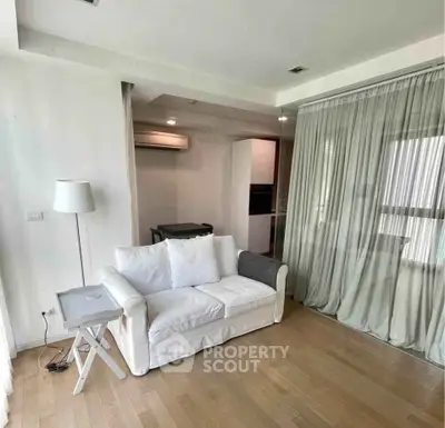 Modern living room with white sofa, wooden flooring, and elegant curtains in a stylish apartment.