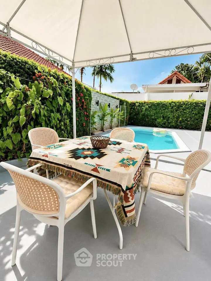 Charming outdoor patio with pool, perfect for relaxation and entertaining in a tropical setting.