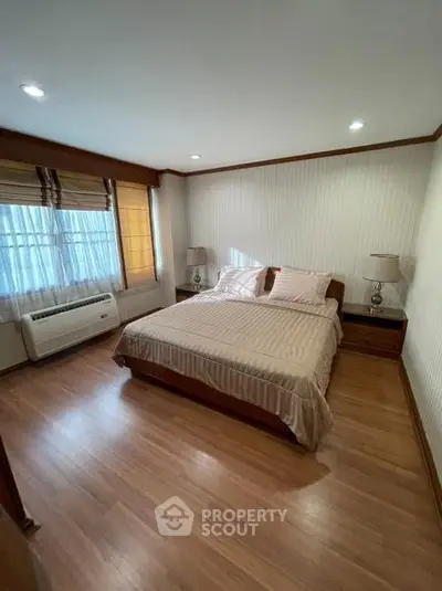 Spacious bedroom with elegant decor and natural light, featuring a comfortable bed and stylish furnishings.