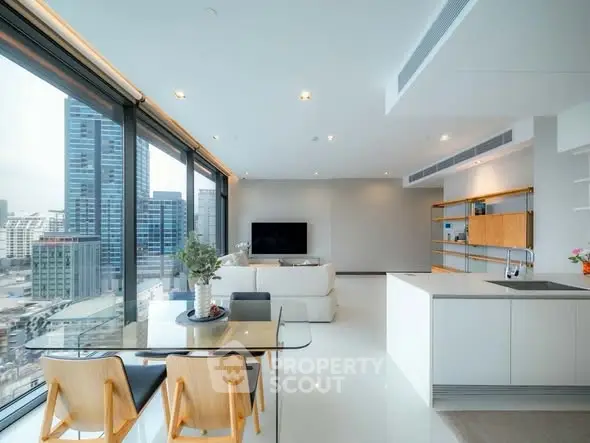Luxurious modern living room with panoramic city views and sleek open kitchen design.