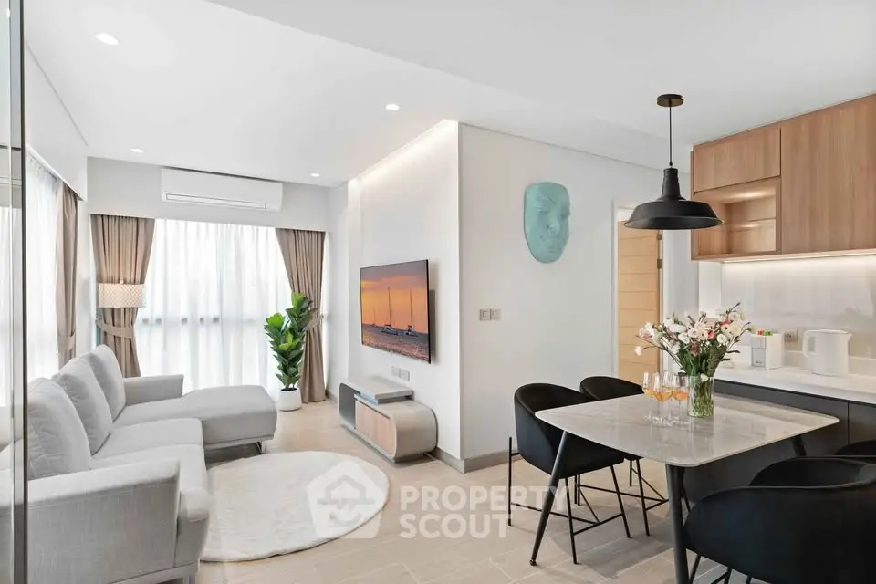 Modern living room with open kitchen, stylish decor, and natural light