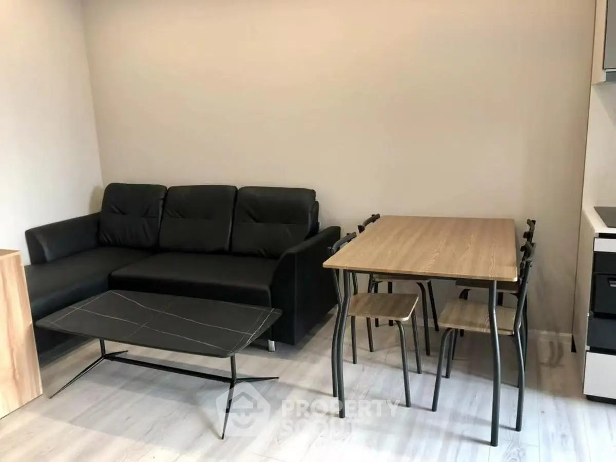 Modern living room with sleek black sofa and stylish dining set