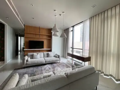 Spacious modern living room with elegant decor and large windows offering natural light.
