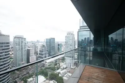 Stunning cityscape view from a modern high-rise balcony with glass railing.