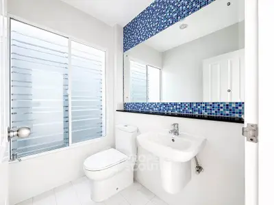 Modern bathroom with sleek fixtures and large mirror in a bright, minimalist design.