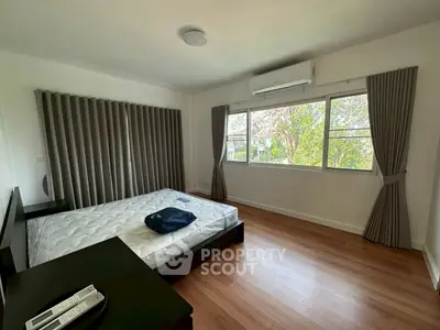 Spacious bedroom with large windows and modern furnishings