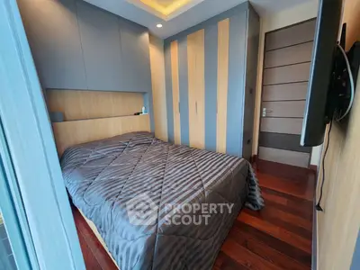 Modern bedroom with sleek design and wooden flooring, featuring built-in wardrobe and cozy bed.