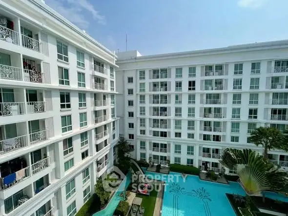 Luxurious apartment complex with stunning pool view and modern architecture.