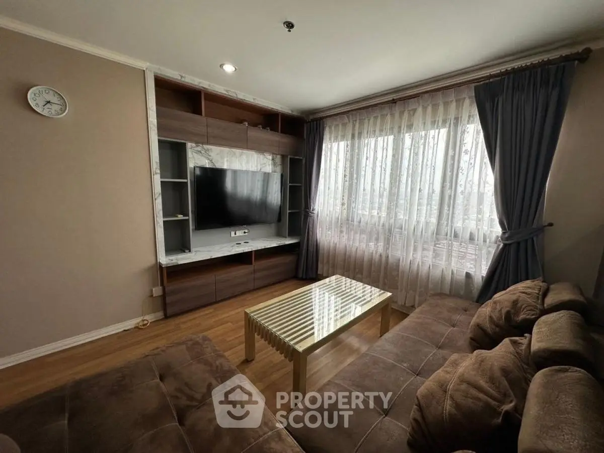 Cozy living room with modern TV setup and plush sofas, perfect for relaxation.