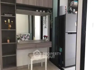 Modern interior with stylish vanity and sleek refrigerator in compact space.