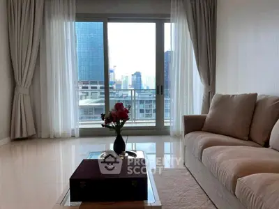 Spacious living room with city view, elegant sofa, and natural light.