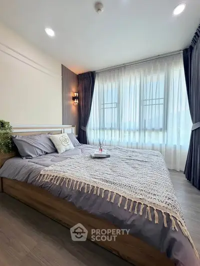 Spacious bedroom with elegant decor and large windows for natural light.